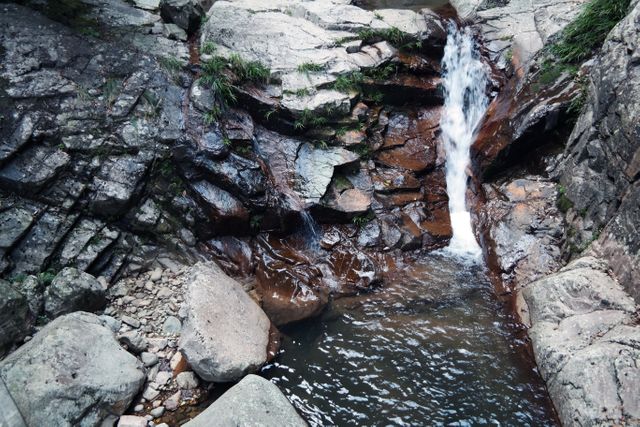 Small Waterfall Flowing Between Rocks in Natural Setting - Download Free Stock Photos Pikwizard.com