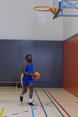 Basketball Player Aiming to Score on Indoor Court