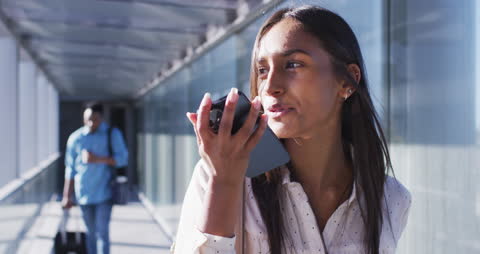 Confident Young Woman Utilizing Smartphone in Modern Office