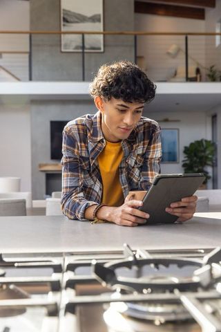 Tech-Savvy Young Man Using Tablet in Modern Kitchen