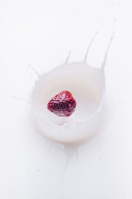 This depiction of a fresh strawberry plunging into milk creates a dynamic scene with high energy and realism, emphasizing both movement and freshness. Useful for concepts of nutrition, healthy diet promotions, food and beverage advertising, and splash photography. Great for blogs, culinary websites, food magazines, and social media content focusing on fresh produce and dairy products.