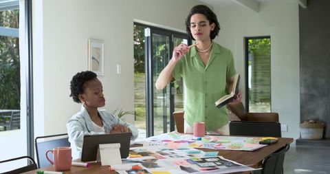 Diverse designers collaborating on moodboard and color swatches at home studio