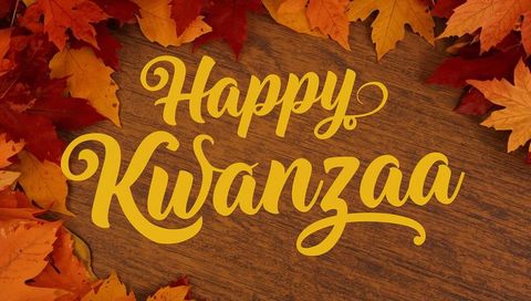Happy Kwanzaa Hand-Lettered Gold Script on Wooden Tabletop with Autumn Leaves