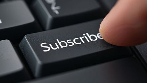 Fingertip Pressing Subscribe Key on Black Keyboard Macro Close-Up