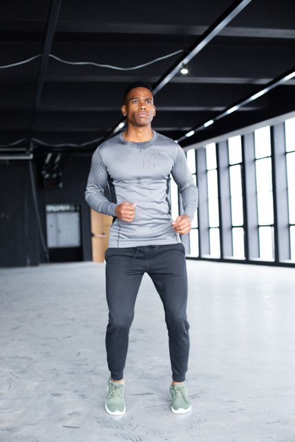 African american man wearing sports clothes and jogging in empty building. urban fitness healthy lifetyle.