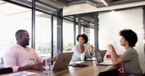 Diverse Group Collaborating in Modern Office with Laptops