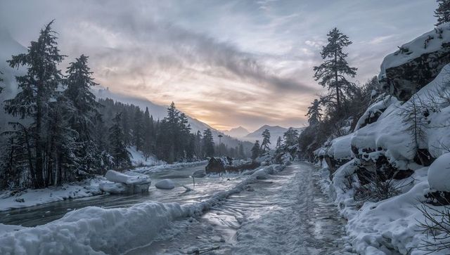 Winding icy mountain trail at sunrise through snow-covered alpine valley with frozen river