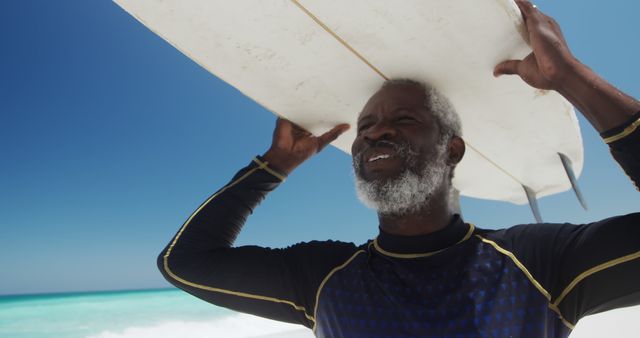 Elderly Man Carrying Surfboard by Ocean on Sunny Day - Download Free Stock Images Pikwizard.com