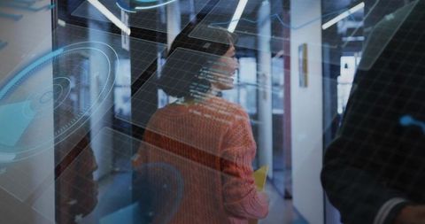 Woman walking holding yellow folder in modern office with holographic tech interface