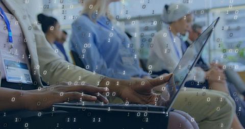 Business attendee typing on laptop with binary data overlay during tech conference