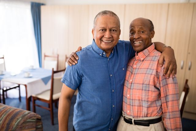 Portrait of smiling senior friends standing with arms around at nursing home
