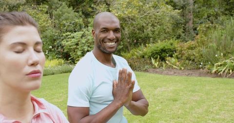 Friends Meditating in Garden with Namaste Gesture