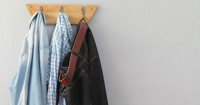 Clothes Hanging on Wooden Coat Rack Against Gray Wall - Download Free Stock Images Pikwizard.com