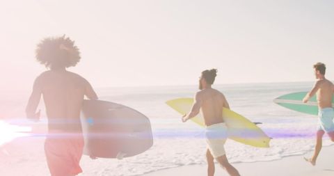 Diverse Friends Running on Sunny Beach with Surfboards