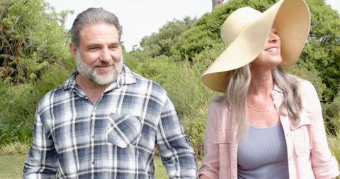 Smiling senior couple enjoying outdoor walk in garden