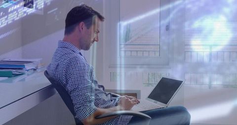 Working man typing on laptop in modern home office with digital data overlay