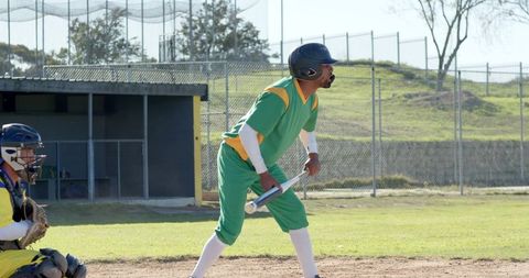 Batter Preparing to Swing in Amateur Baseball Game with Catcher and Dugout