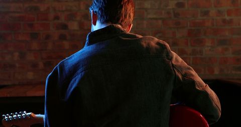 Musician performing solo with electric guitar in intimate venue