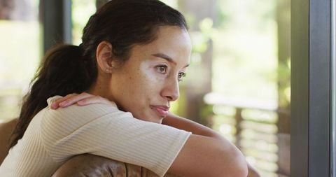 Peaceful Young Woman Contemplating at Bright Window Seat