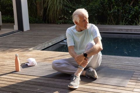 Senior Man Engaging in Relaxing Outdoor Exercise by Poolside