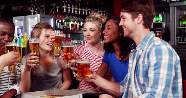 Young adults celebrate at a bar with drinks, pizza, and cheerful toasts. - Download Free Stock Photos Pikwizard.com
