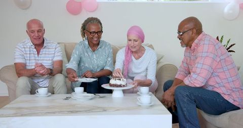Senior Friends Sharing Cake Celebrating Cancer Survivor
