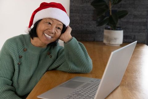 Woman in santa hat using laptop at home during holiday season