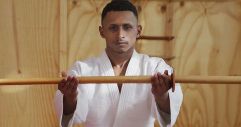Focused Young Judoka Training with Jo Staff in Gym