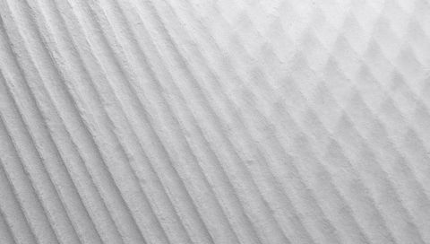 Minimalist ribbed paper texture featuring diagonal ridges and soft gradient lighting