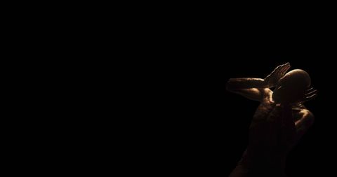 Distressed figure in dark room expressing fear and horror
