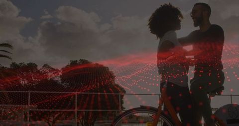 Couple embracing on bicycle with red digital grid overlay