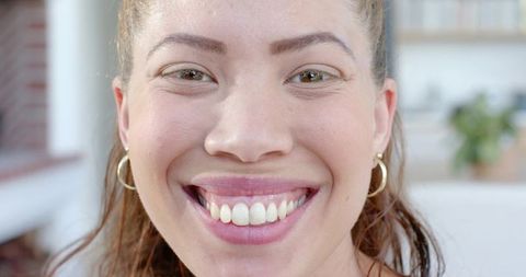 African american woman smiling with bright teeth and gold hoop earrings closeup portrait