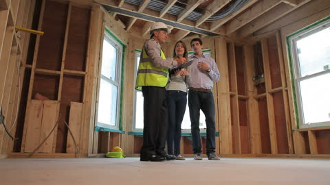 Architect Discussing House Plans with Couple in Open Construction Site