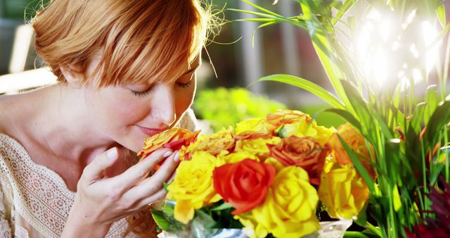 Beautiful female florist smelling roses in flower shop
