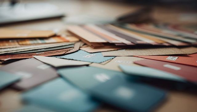 Displaying color swatch and fabric sample palette on wooden table with label codes