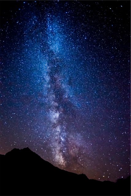 Spectacular view of the Milky Way shining brightly over a silhouetted mountain peak during a clear night. Perfect for publications on astronomy, space exploration, and outdoor adventures. Ideal for use in astronomy presentations, educational materials, nature-themed articles, and posters celebrating the beauty of the night sky.