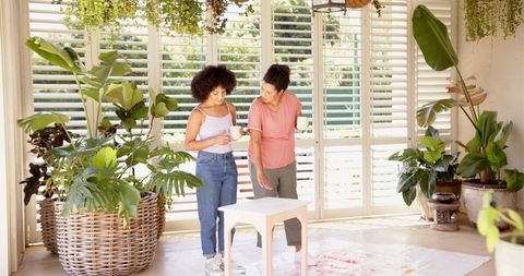 Mother and Daughter Collaborate in Bright Room with Plants for DIY Project