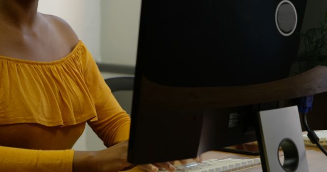 Woman Typing on Computer Wearing Yellow Off-Shoulder Blouse - Download Free Stock Images Pikwizard.com