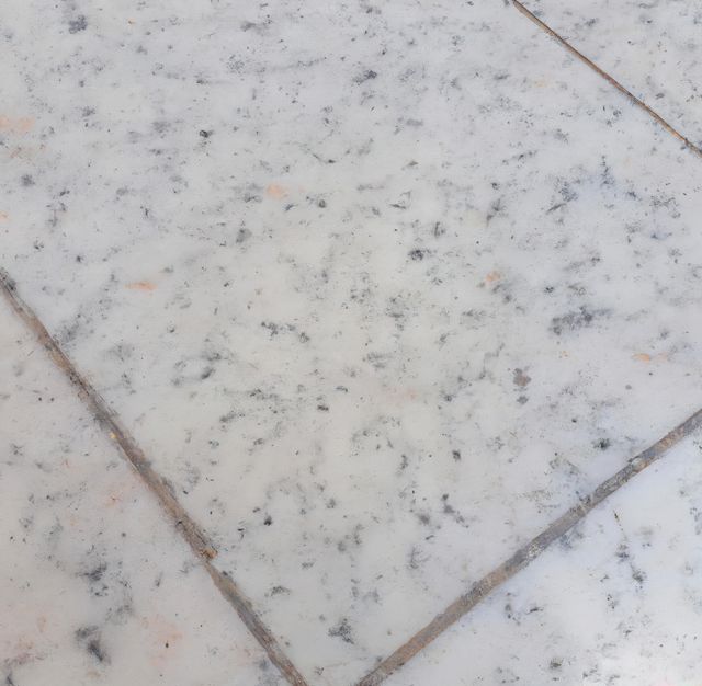 Marble tile flooring exhibiting a speckled pattern ideal for use in bathrooms, kitchens, and entryways. The image showcases the intricate details and variations within the marble, highlighting its natural beauty. Perfect for design inspirations, interior decorating ideas, and home improvement projects.