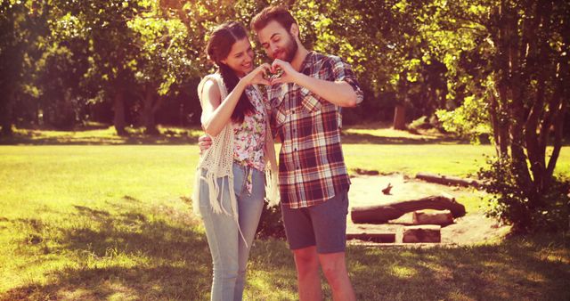 Happy Couple Making Heart Shape with Hands in Sunlit Park - Download Free Stock Images Pikwizard.com