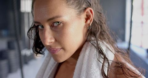 Determined fit woman with towel after intense gym workout