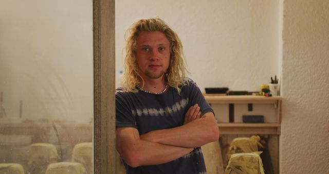 Confident Young Man with Long Blonde Hair Standing in Room - Download Free Stock Images Pikwizard.com