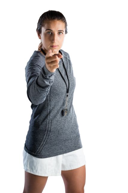 Portrait of female rugby coach pointing while standing against white background