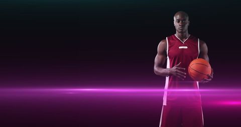 Basketball Player Holding Ball with Vibrant Pink Light