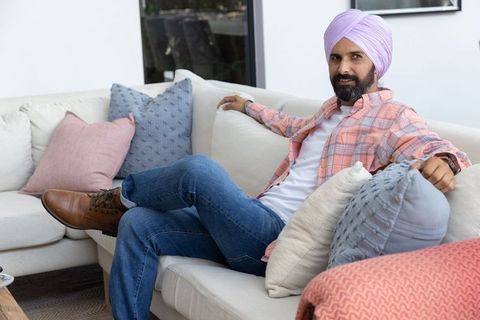 Indian man relaxing on cozy sofa at contemporary home
