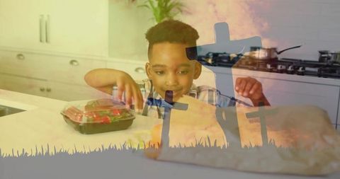 Boy reaching for salad container at kitchen counter with haunting cross silhouette overlay