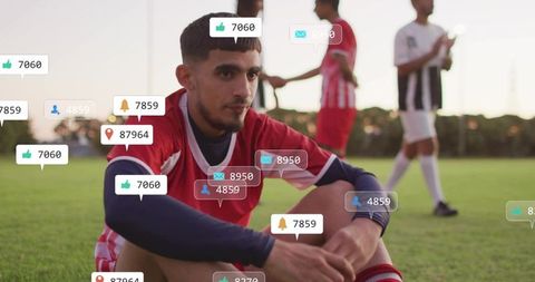 Young soccer player sitting on sideline with social notifications causing emotional strain
