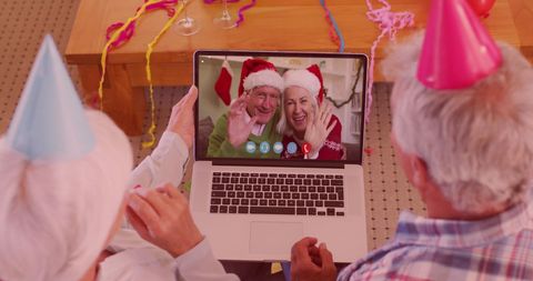 Seniors in party hats video call family for festive celebrations