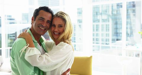 Happy Couple Embracing at Modern Home with City View