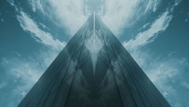 Futuristic glass skyscraper reflecting cloudy sky